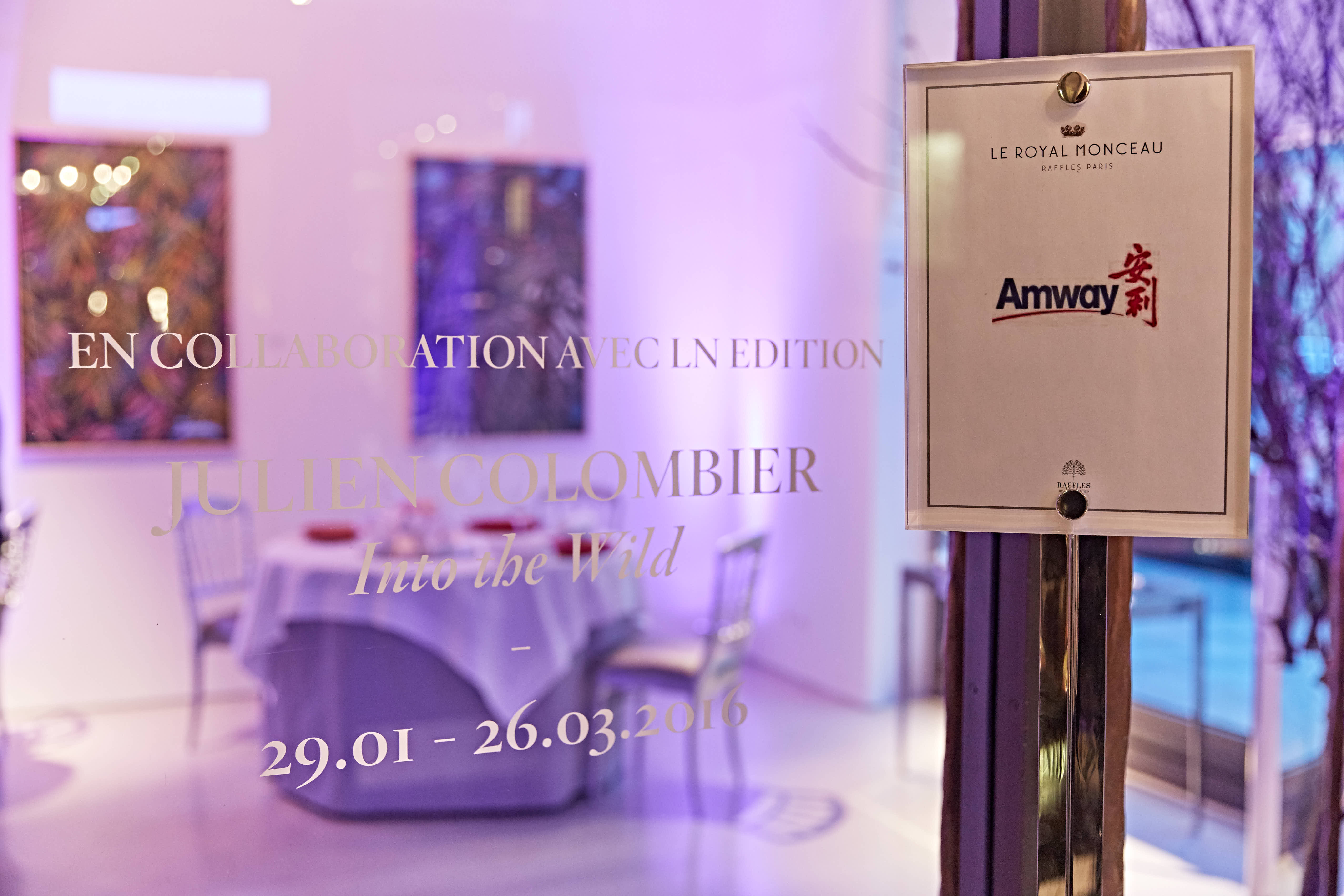 画面右侧悬挂印有“LE ROYAL MONCEAU RAFFLES PARIS”“Amway安利”字样的活动专属标牌，玻璃上标注本次联名活动时间为2016年1月29日-3月26日，背景是布置雅致的活动会场，整体氛围高端精致，契合安利高端品牌调性。