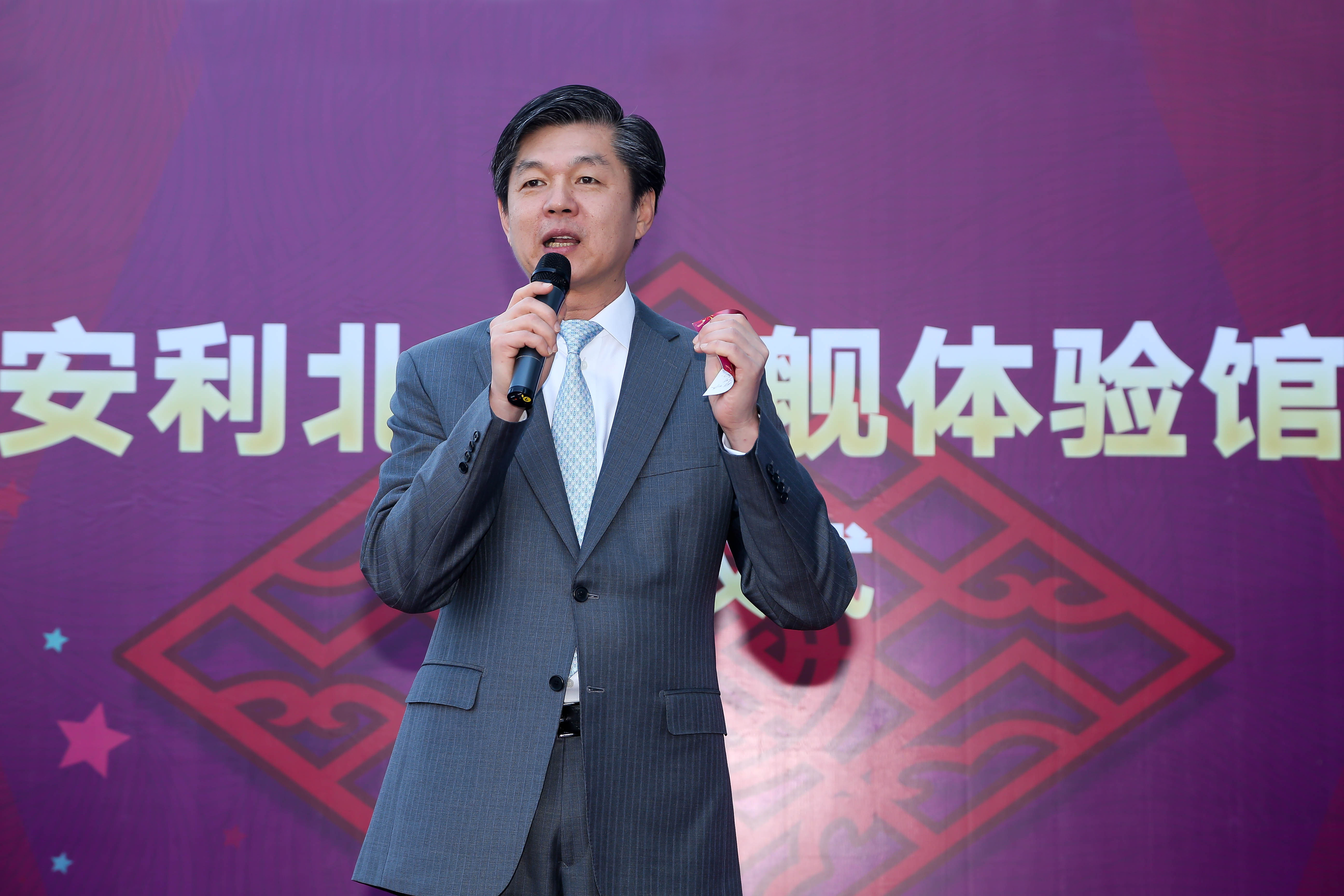 活动背景印有核心文字“安利北京旗舰体验馆”，身着正装的领导手持话筒正在现场致辞，整体氛围庄重热烈，充分彰显安利品牌活动的专业质感与积极正向的品牌风貌。