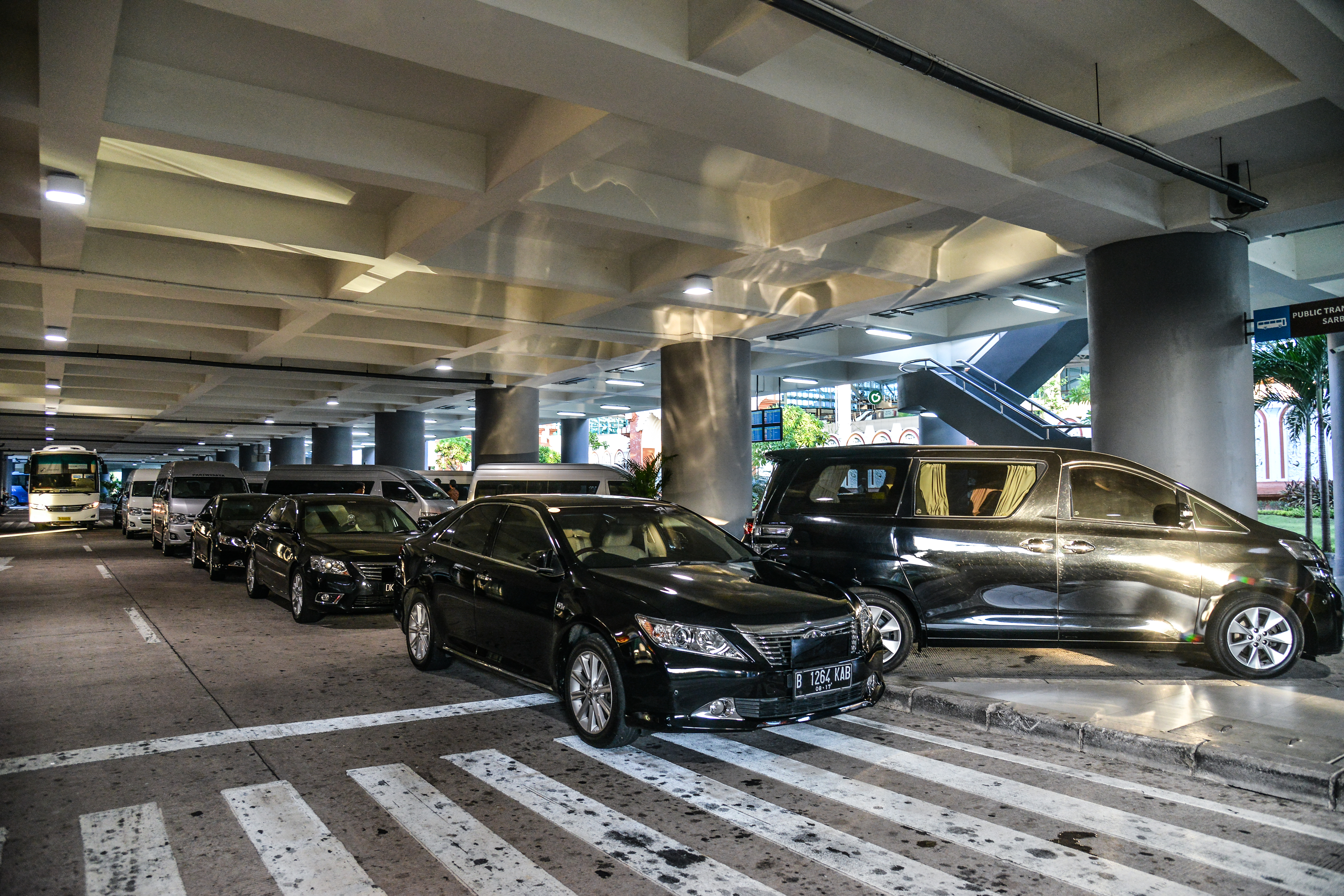 宽敞的公共交通接驳场地内，多辆轿车、商务车整齐停放、车况良好，作为安利品牌活动专属接待用车整装待命，为参会嘉宾提供专业舒适的出行保障，尽显活动筹备的细致周到与品牌贴心的服务理念。