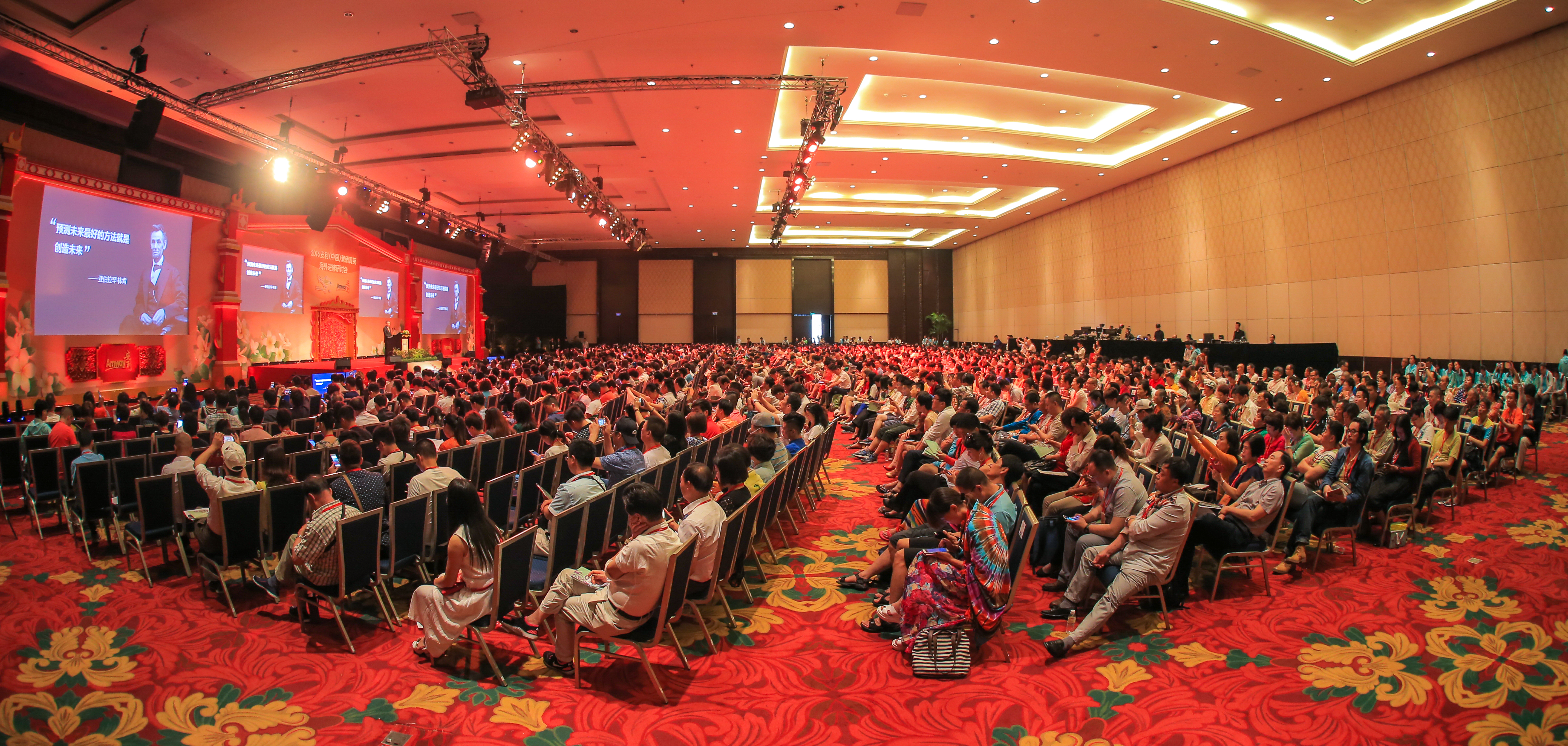 2016安利（中国）营销菁英研讨会现场，宽敞会场内坐满各地营销伙伴，前方舞台显示屏展出“预测未来最好的方法就是创造未来”的内容，现场灯光明亮、氛围庄重热烈，参会人员专注投入，共赴本次进修交流盛会。