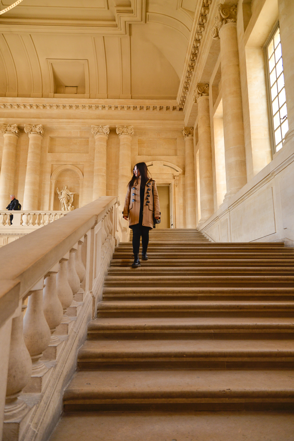 暖光透过侧窗洒在凡尔赛宫典雅的石质阶梯上，周边是精美的欧式立柱与雕刻，建筑恢弘大气。参与本次海外研讨会的安利伙伴正缓步走下阶梯，氛围悠然舒展，尽显本次行程的高端质感，让伙伴在领略异域风光的同时收获尊崇体验。