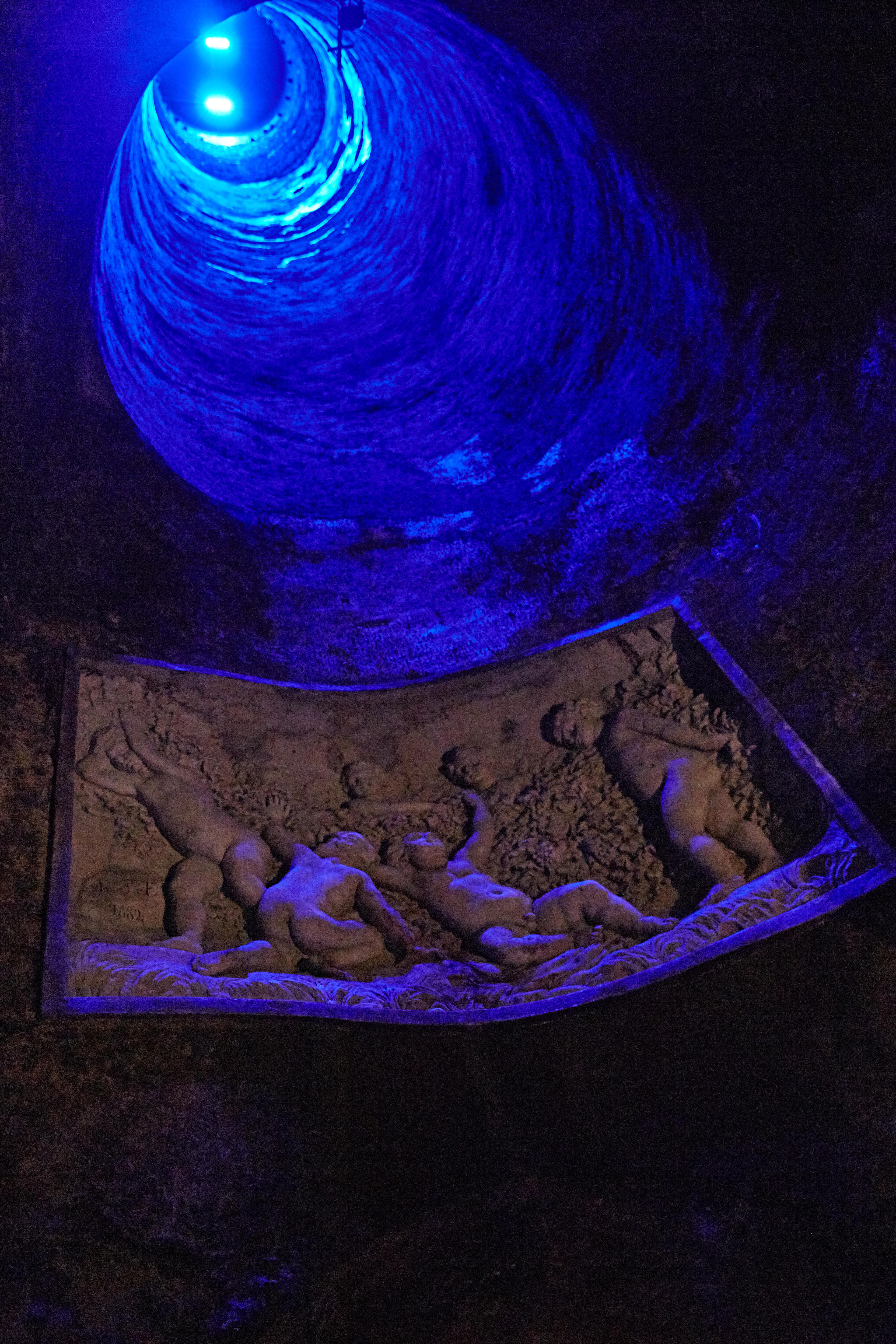 现场为洞穴风格沉浸式空间，幽蓝色灯光点亮螺旋状穹顶，墙面嵌有标注“1682”字样的孩童主题浮雕，整体氛围静谧梦幻、艺术感十足，为参与活动的伙伴带来独特的感官体验。