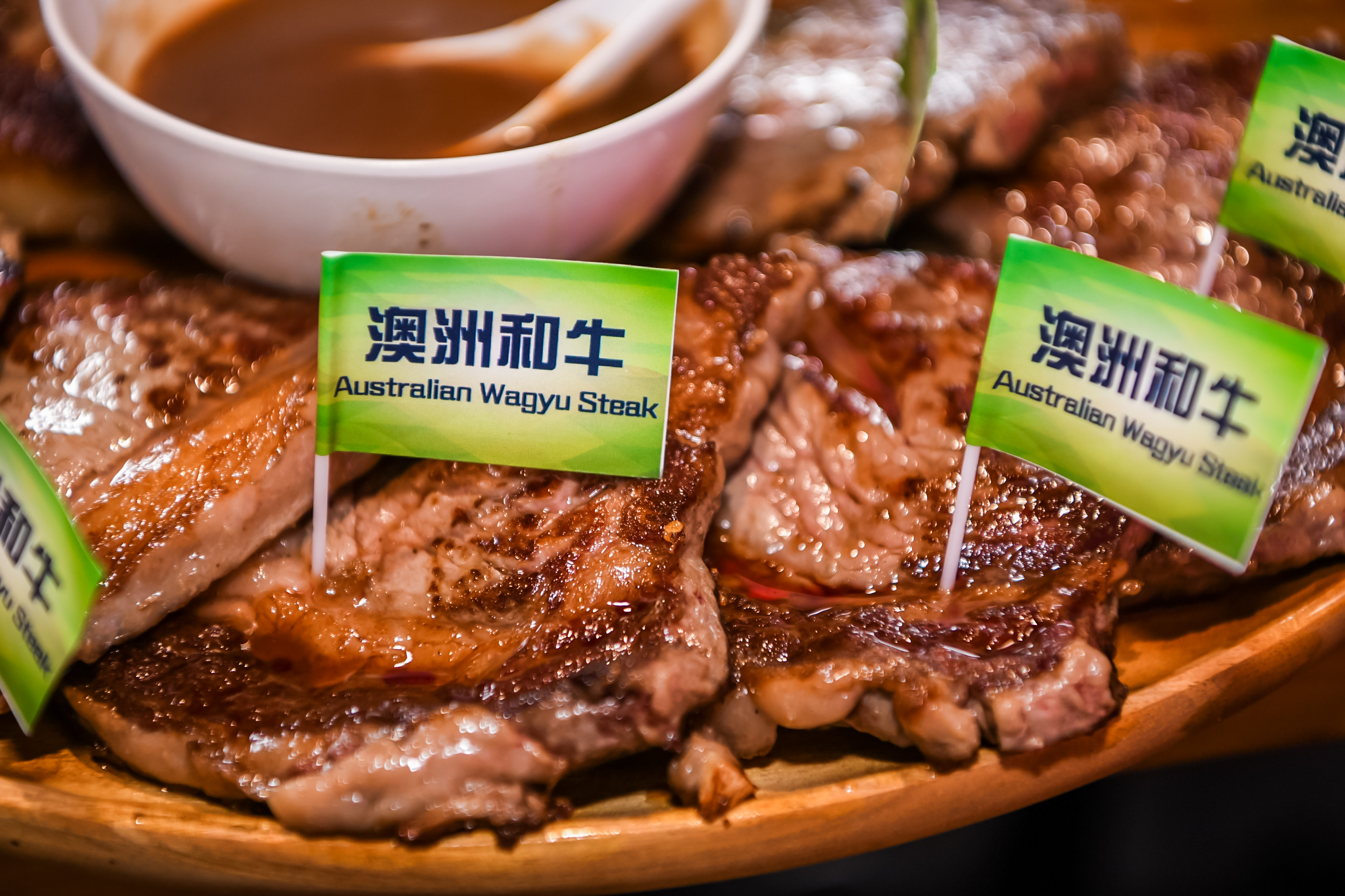 本次安利品牌活动餐区展出的精品澳洲和牛（Australian Wagyu Steak）煎制后油亮丰润、色泽诱人，整齐码放在木质餐盘上，旁配调味酱汁，餐品品质上乘，尽显活动贴心周到的服务安排，为参与人员带来高品质用餐体验。