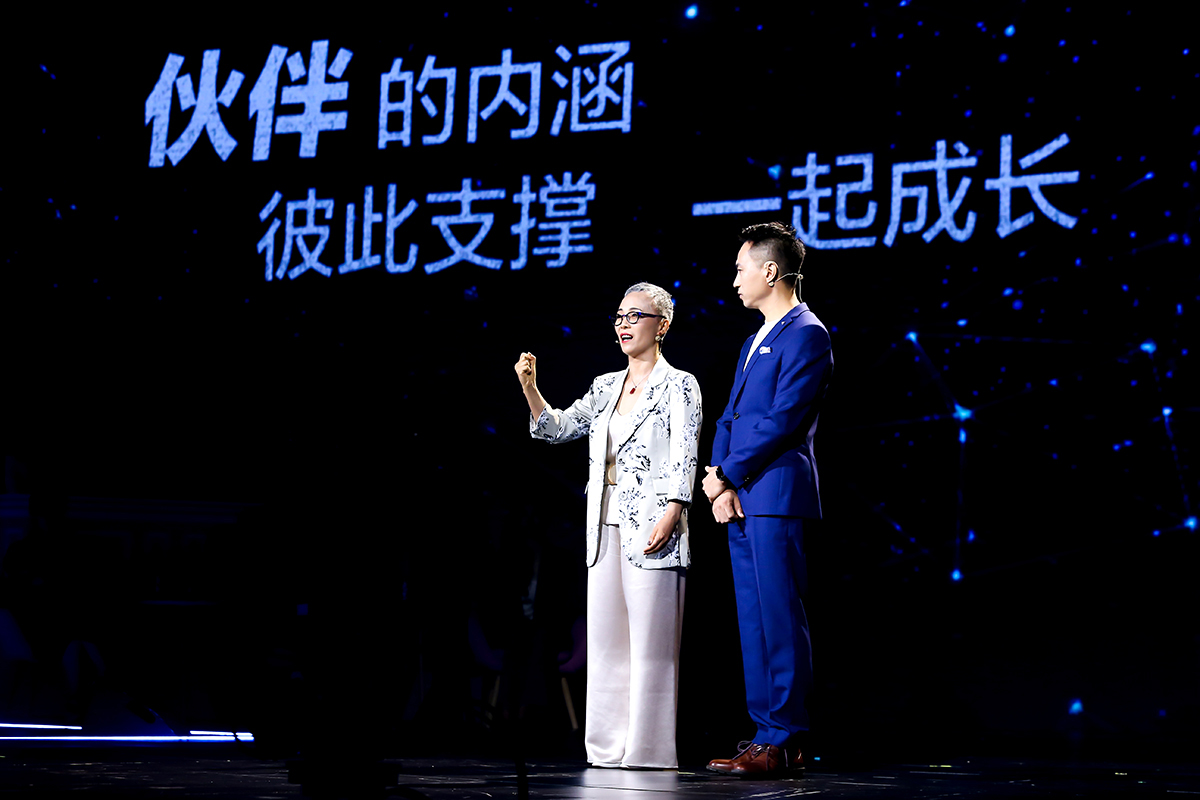 本次安利品牌活动现场，背景大屏显示“伙伴的内涵 彼此支撑 一起成长”字样，两位身着正装的嘉宾站在星光质感的舞台上，女嘉宾抬手动情分享，现场氛围积极正向，传递出安利伙伴携手支撑、相伴成长的核心理念。