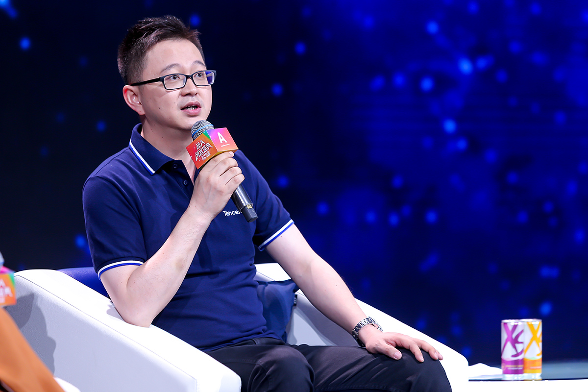画面为安利超A创客盛典活动现场，受邀嘉宾手持印有“超A创客盛典”标识的话筒正进行交流分享。现场背景为科技感蓝色星空效果，桌边摆放安利XS系列饮料，整体氛围专业正向，充分展现活动开放探讨的良好风貌。
