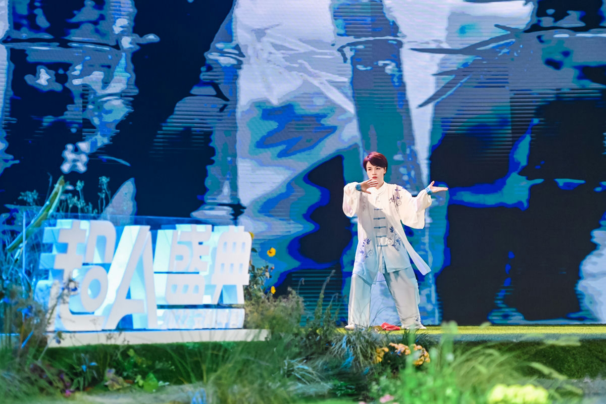安利超A盛典活动现场，身着素雅太极服的表演者正于舞台上展演太极，动作舒展从容。舞台旁设发光“超A盛典”主题字，背景是水墨山水风格大屏，台前布置鲜活绿植花艺，整体氛围舒缓雅致，传递出健康自然的生活理念，契合活动正向基调。