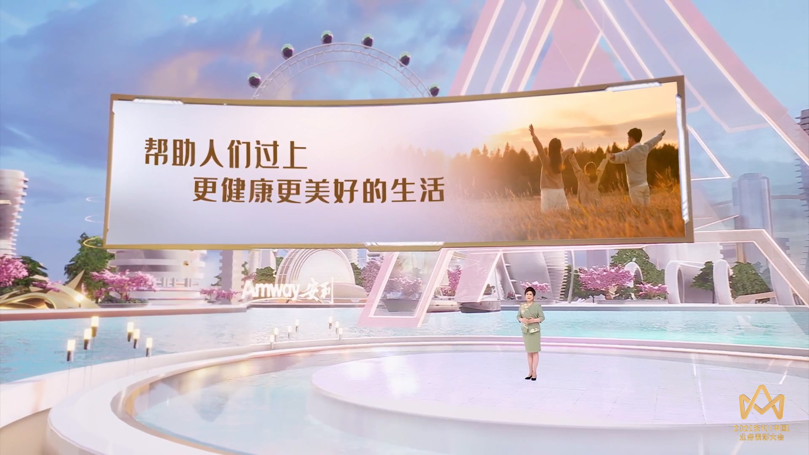 本画面为2022安利（中国）业务表彰大会现场，科技感十足的舞台区域印有“Amway安利”品牌标识，主讲人站在舞台中央宣讲，背景大屏醒目呈现“帮助人们过上更健康更美好的生活”的品牌理念，搭配温馨的家庭场景画面，整体氛围明亮温暖，尽显大会正式隆重的基调。