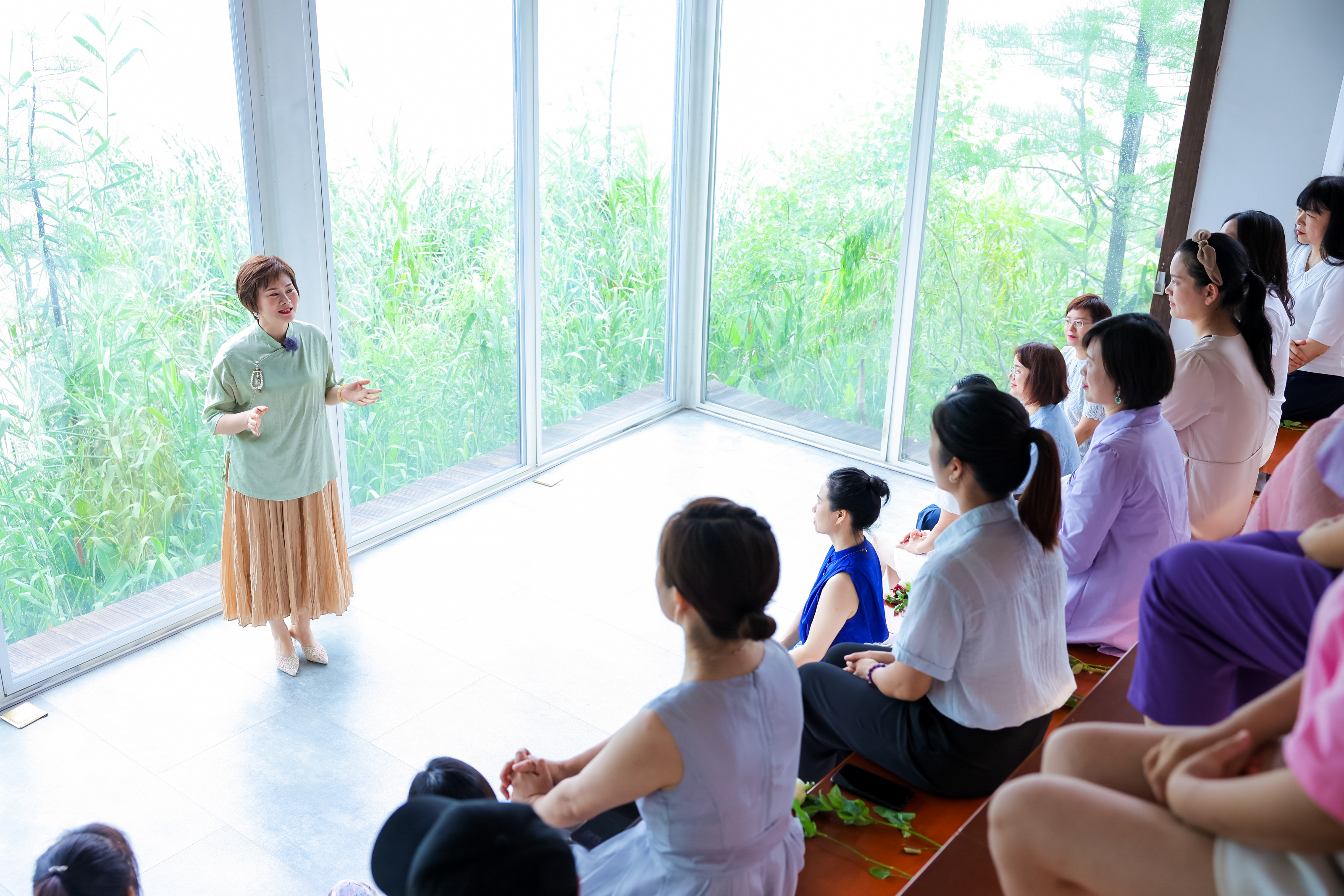 本次活动在临着户外绿植的全景落地窗空间举办，主讲老师正面向围坐的安利女性伙伴做成长主题分享，大家全神贯注聆听，现场氛围轻松积极，充分展现安利赋能女性成长、助力伙伴交流提升的品牌温度，传递满满正能量。
