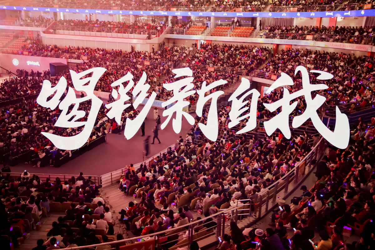 画面醒目呈现核心文字“喝彩新自我”，大型场馆内座无虚席，各层看台均坐满参会的安利伙伴，现场氛围热烈高涨，充分彰显活动超高人气，传递出安利积极昂扬的品牌风貌。