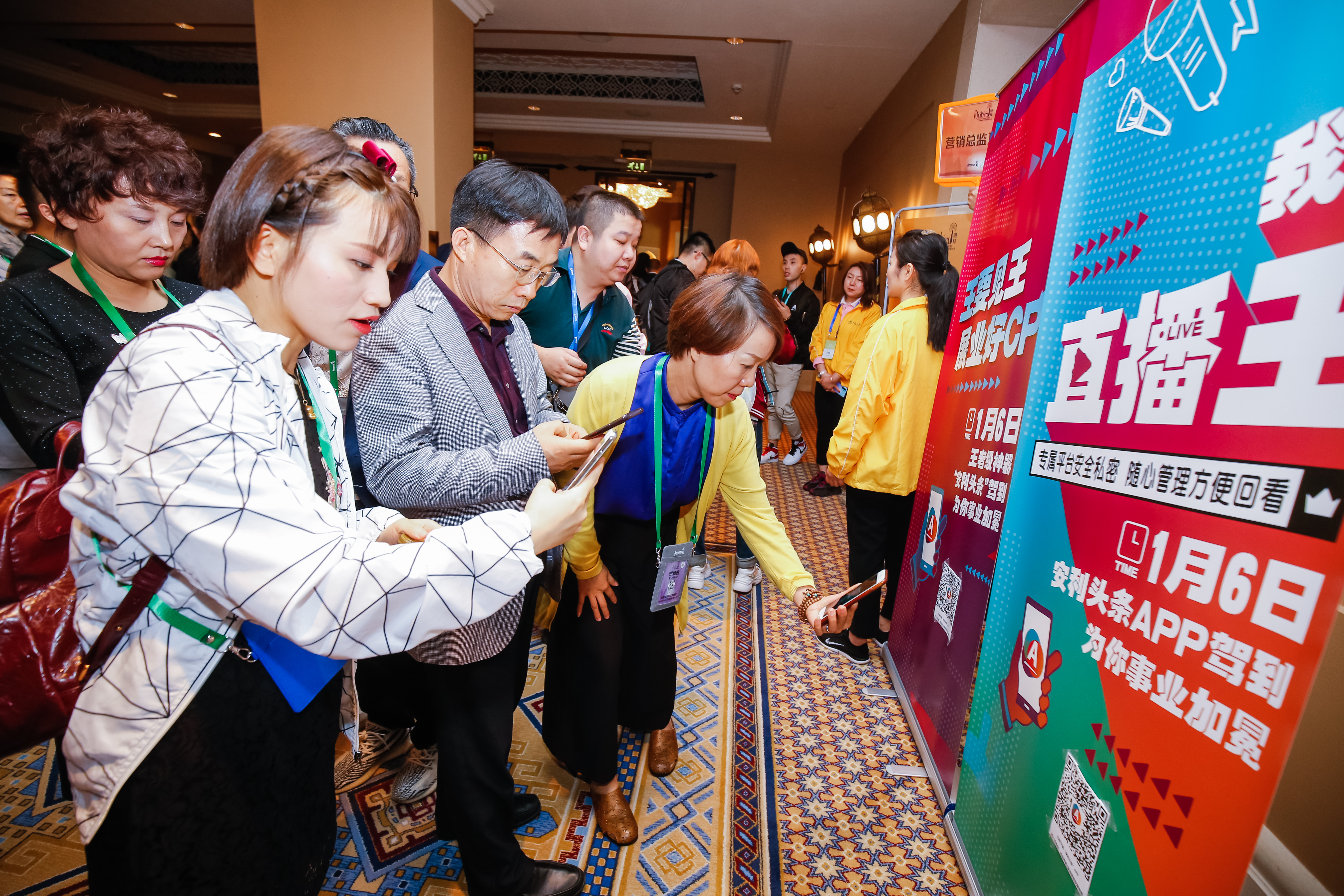 本次安利活动现场，参会人员聚集在印有“直播王”“1月6日 安利头条APP驾到 为你事业加冕”等字样的宣传展架旁，纷纷拿出手机扫码了解APP相关信息，现场氛围热闹活跃，伙伴们参与度极高，尽显对新运营工具的高度热情。