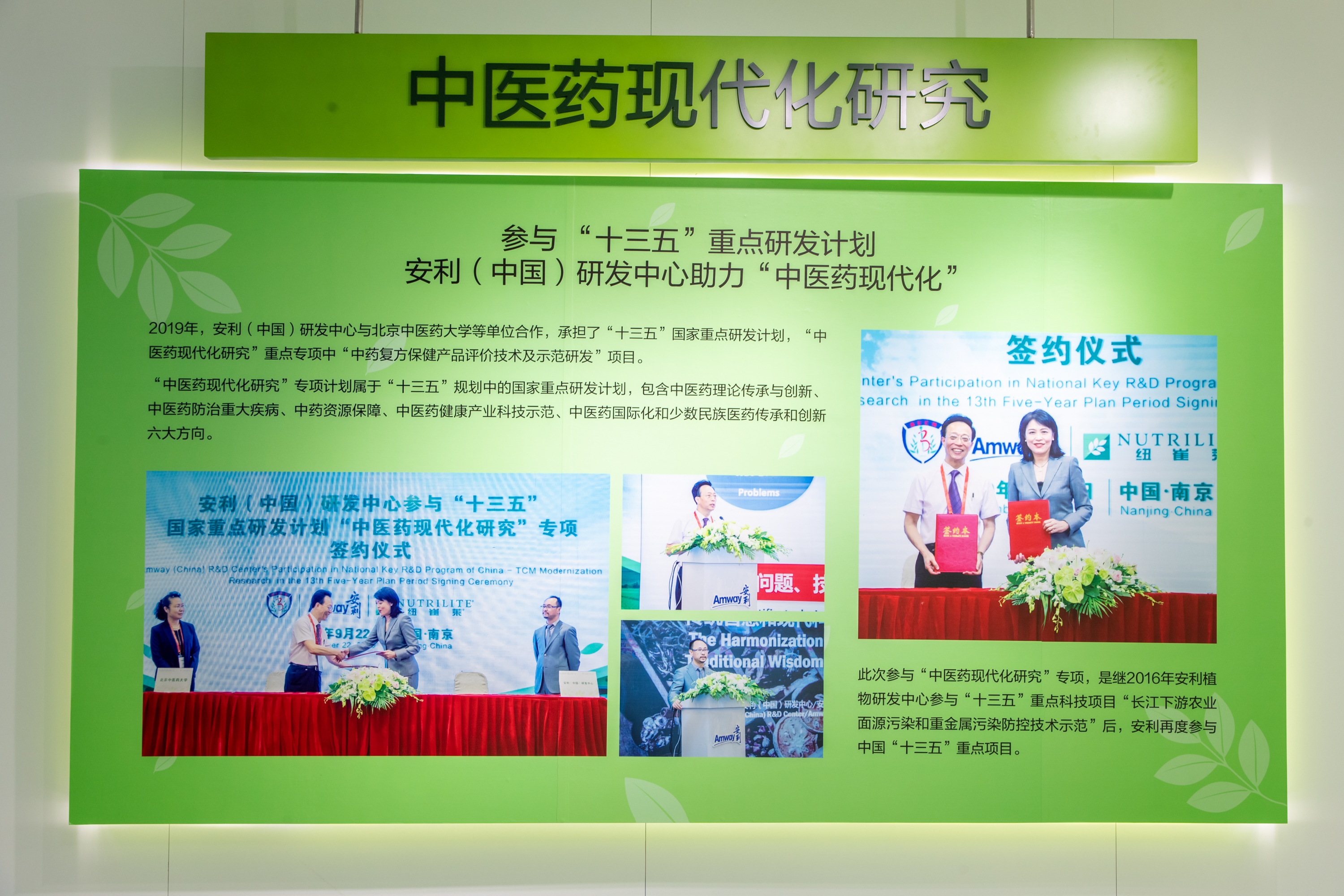 本块绿色主题展板围绕“中医药现代化研究”主题，展示安利（中国）研发中心参与“十三五”重点研发计划、助力中医药现代化的相关内容，介绍2019年安利联合北京中医药大学等承担相关专项的情况，搭配签约仪式、项目宣讲现场照片，风格正式专业，彰显企业科研实力。