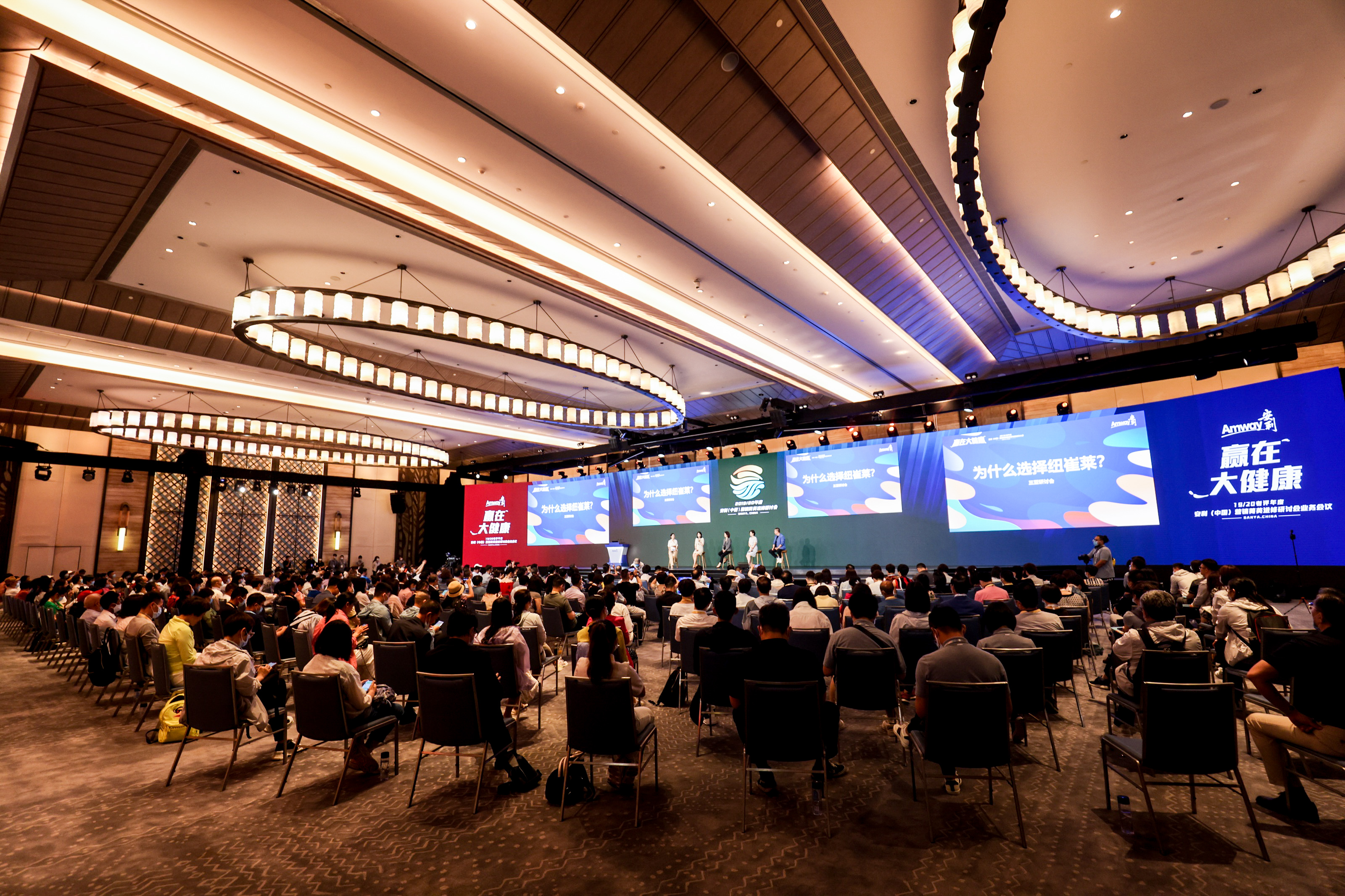 这是安利“赢在大健康”主题研讨会现场，会场内座无虚席，参会人员正专注参会。舞台大屏展示“为什么选择纽崔莱”研讨议题，台上嘉宾就位待开展分享交流，现场氛围庄重热烈，充分展现安利深耕大健康领域的专业风貌。